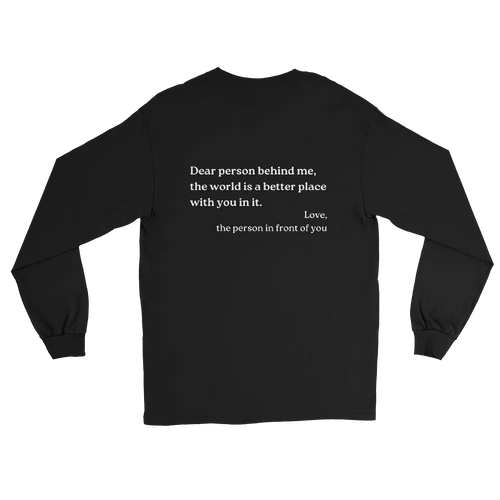 A black long-sleeve t-shirt with white printed text on the back "dear person behind me, the world is a better place with you in it. Love, the person in front of you", displayed against a solid white background.